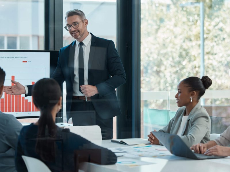 Meeting, training and planning with a CEO, manager or leader and his team in the boardroom. Collaboration, workshop and presentation with a business man and staff talking about vision and mission